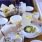 two people bringing drinks together over a table of food